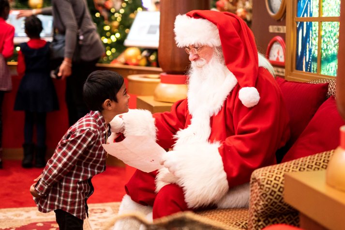Santa Claus talking to a boy in one of the fun activities for kids in Singapore