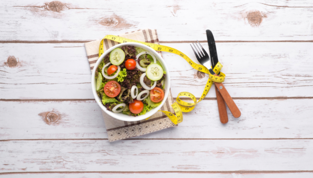 a bowl of salad on top of a napkin and tape measure