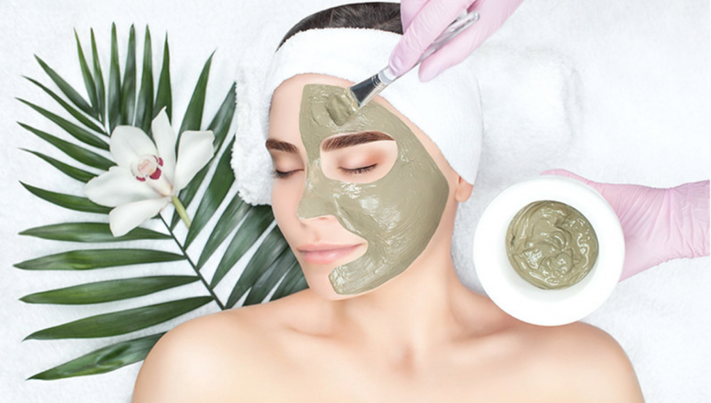 woman lying down while doing skincare routine with a facial mask