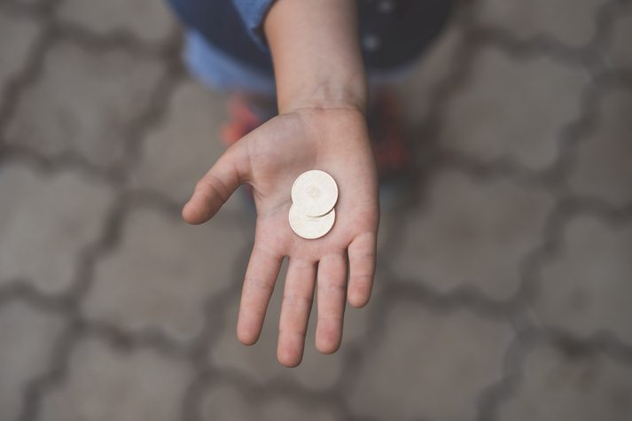 coin on a child's hand to help teach financial literacy for kids
